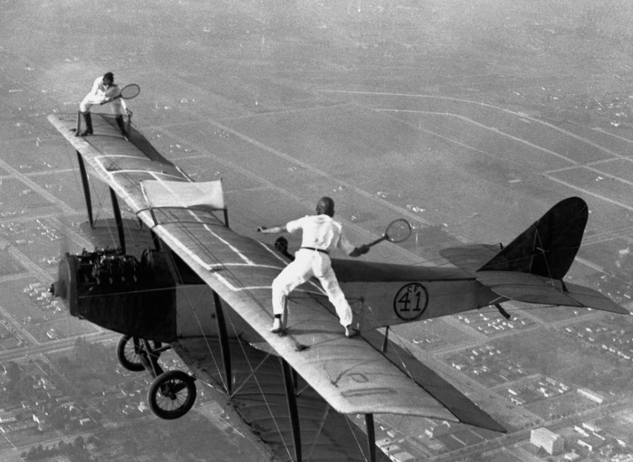 Gladys Roy and Ivan Unger playing a game of tennis on the wings of a biplane above Los Angeles in 1925.
